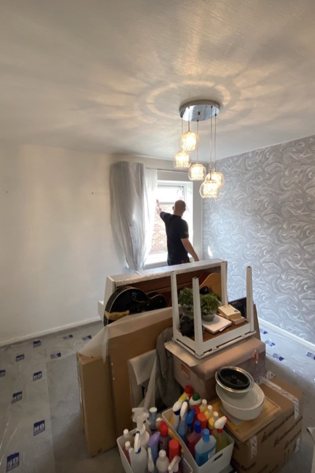 Everything from the shelves and floor stacked in the centre of the room, leaving all four walls clear - preparing a home for a house rewire